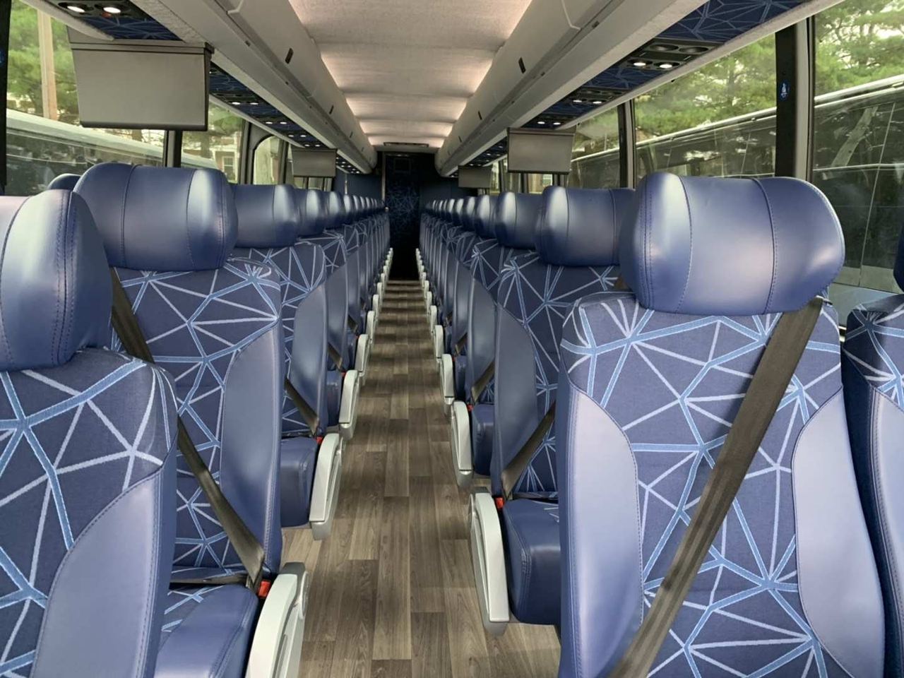 Rows of reclining blue leather seats inside a J&F Tours coach
